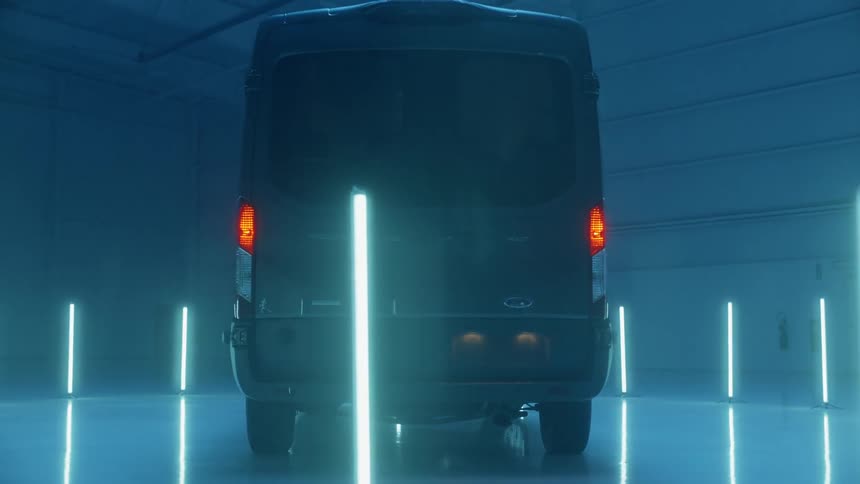 Black van parked in a large garage illuminated by many blue lights