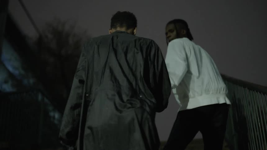 Two people walk up the steps at night