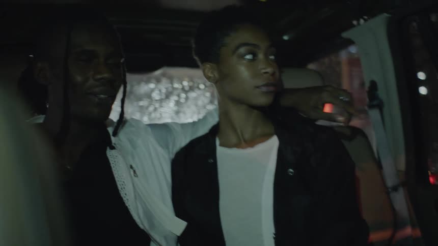 Two people ride in the back of a car