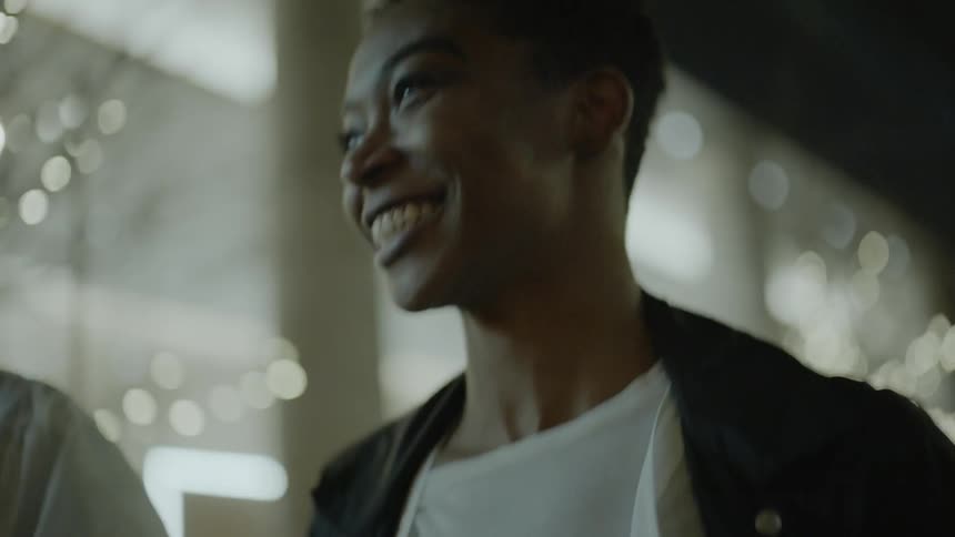 Man and woman walk and smile in the city at night