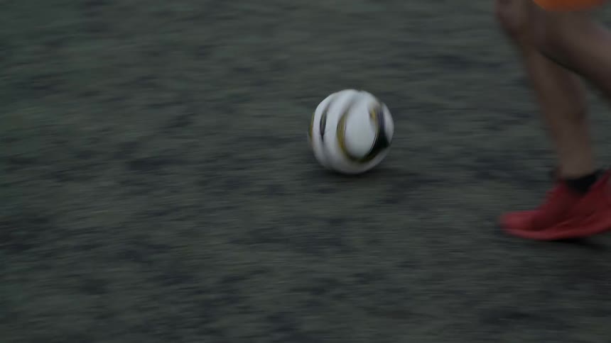 Person kicks a soccer ball in a grassy field