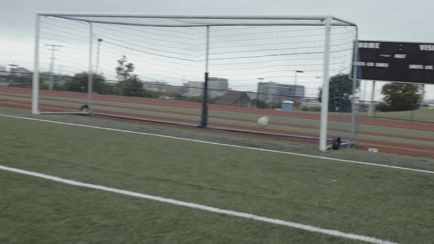 A soccer player scores a goal on an outdoor field