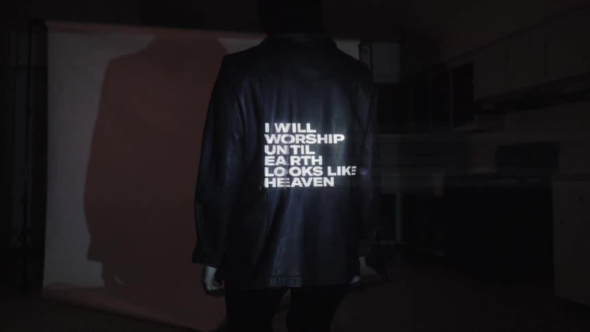 A man stands in front of projected words