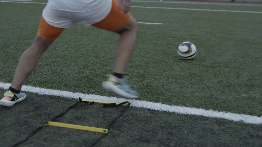 Man kicks a soccer ball into the net