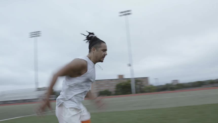 An athlete runs outside on a soccer field