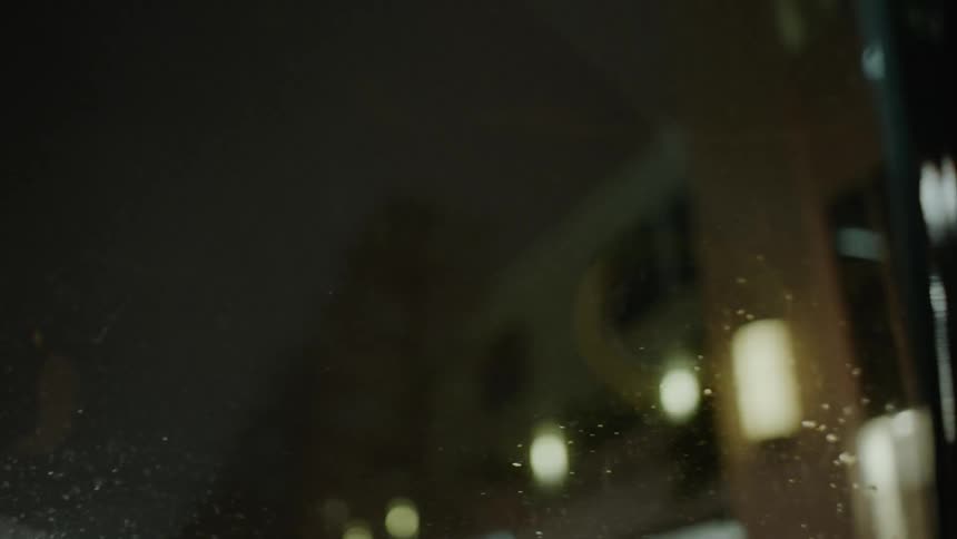 A car is driven on a city street at night