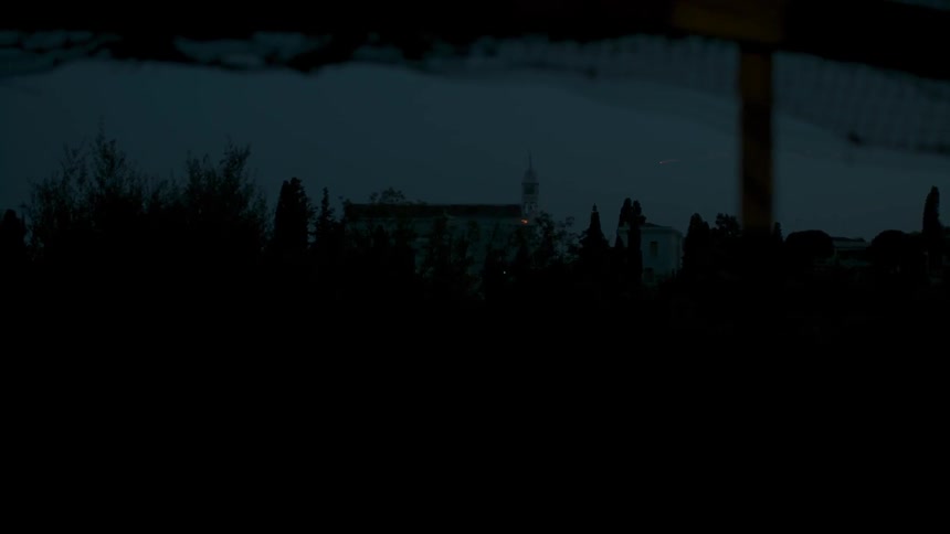 A church sits in a snowy field in the distance