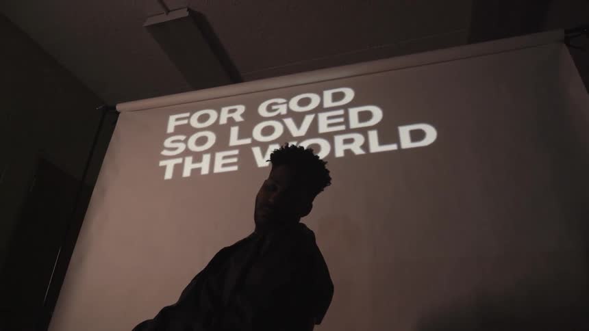 A man sits in front of a projection
