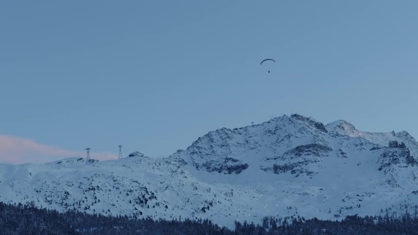 A parachuter glides down from the mountain