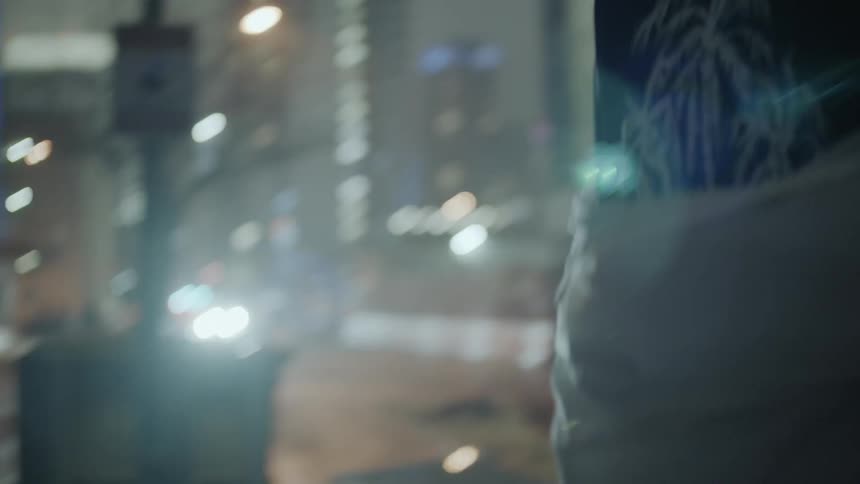 A man puts a jacket on outside at night