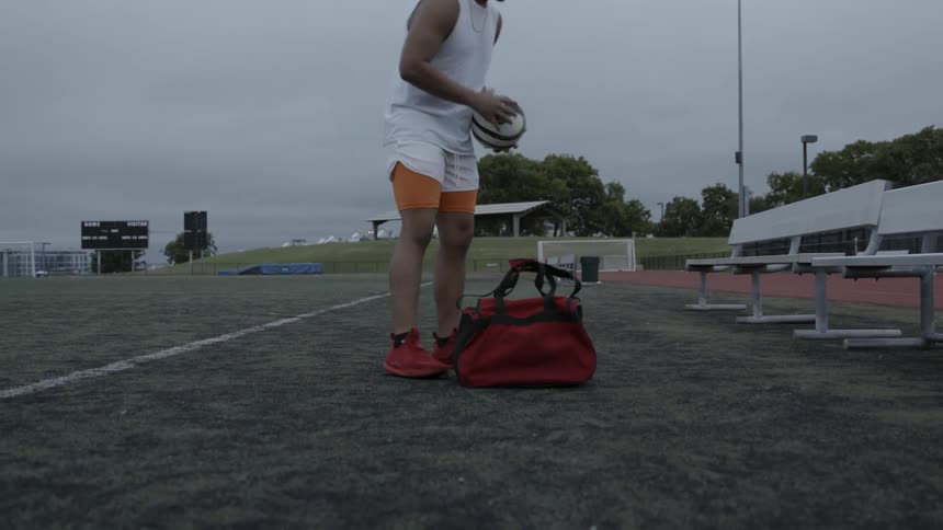 A soccer player practices on an outdoor field