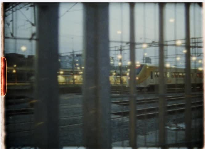 A passenger train travels in a city at night