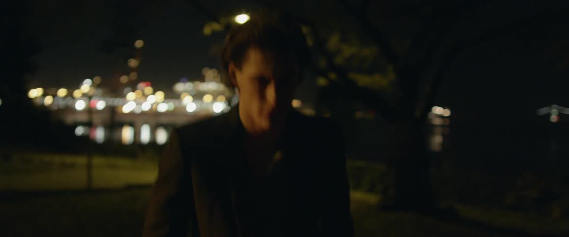 A man walks in a city park at night