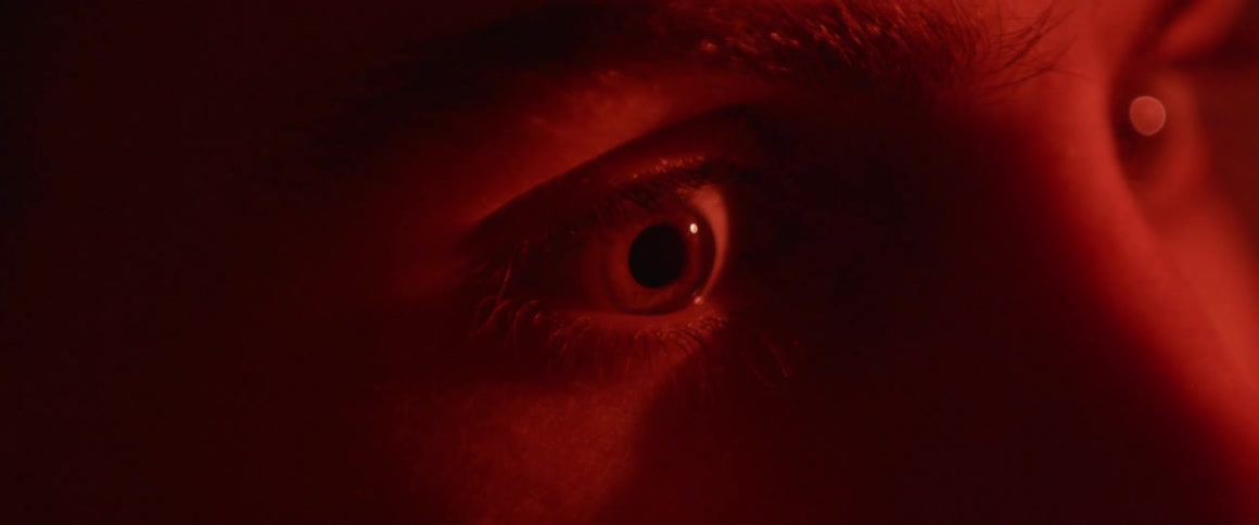 An eye dilates as a red light flashes