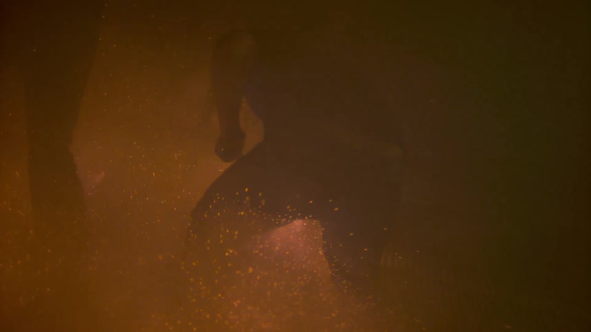 Man splashing in water in a dark area