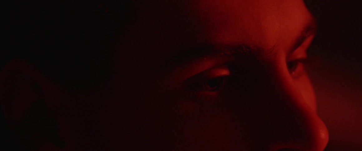 A man opens his eyes as red light flashes