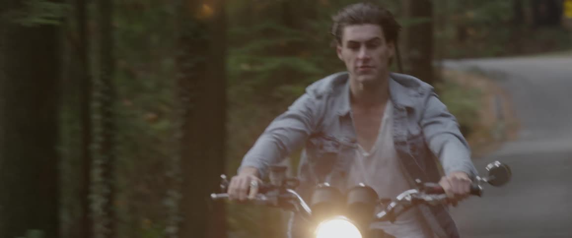 A motorcyclist rides on a rural road