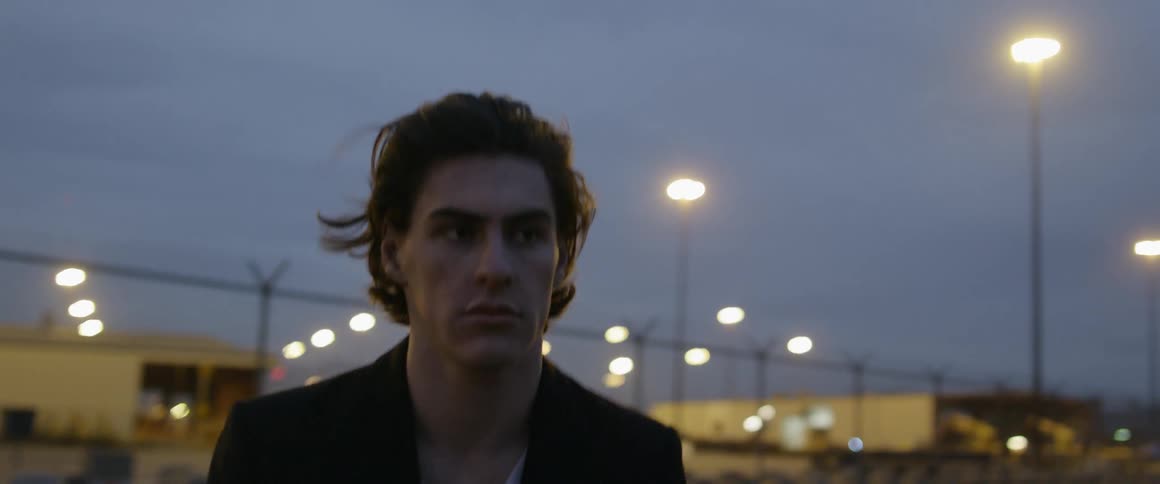 A man walks outside in a city at night