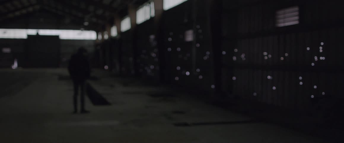 Man stands in a large building and looks at the lights on the wall