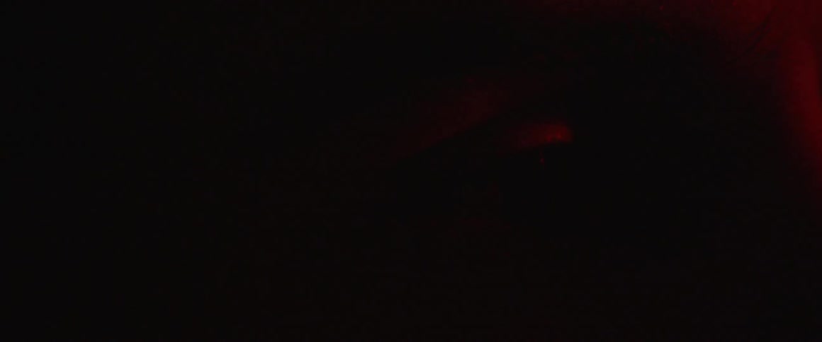 An eye dilates as a red light flashes