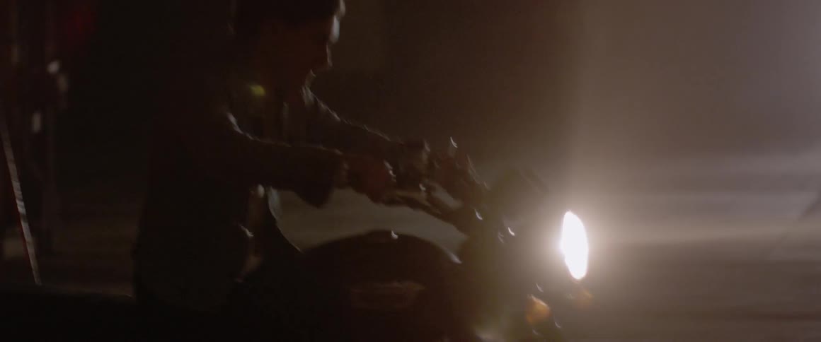 A motorcyclist rides at night