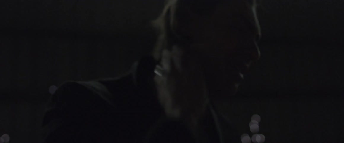 A man cries in a dark warehouse
