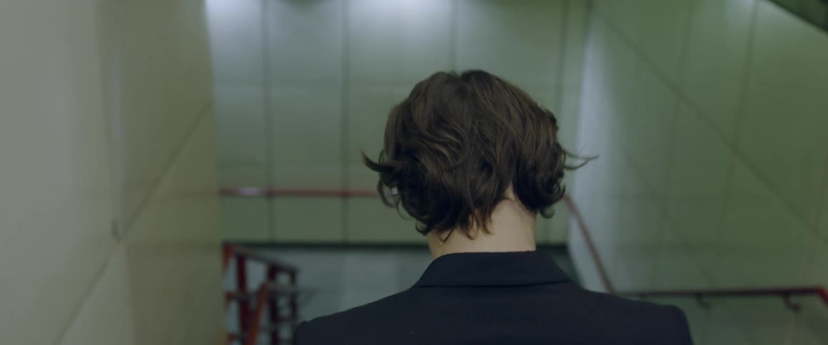 A man climbs down stairs in a building