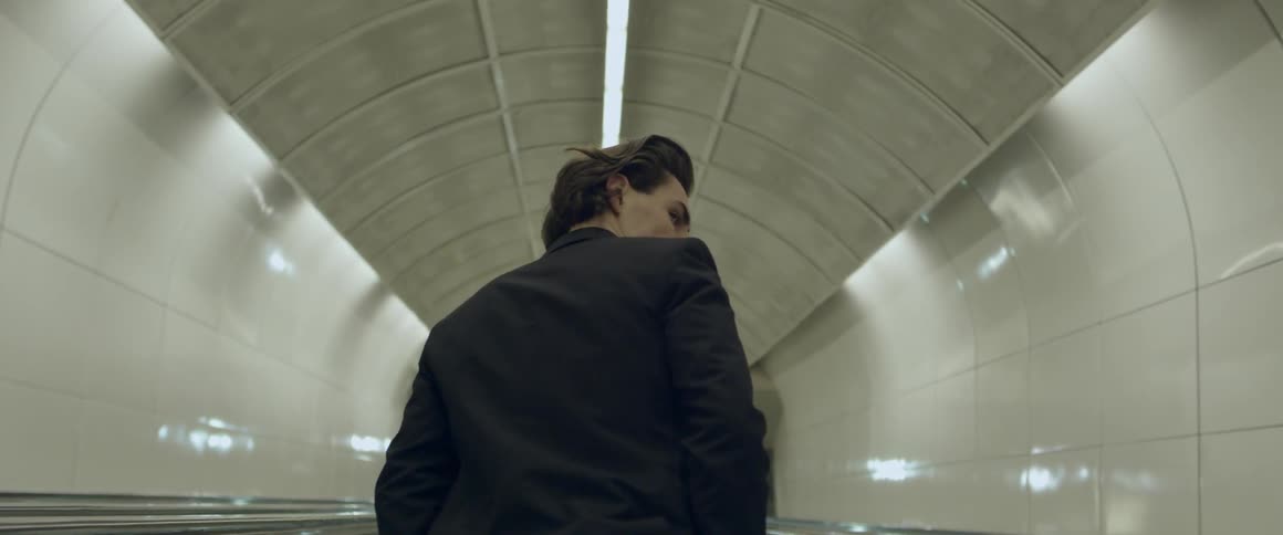 Man standing on escalator in a subway tunnel