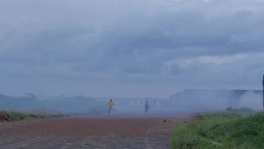 Two young boys race down a dusty path