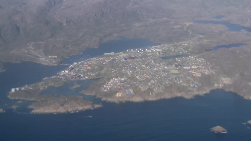 Aerial shot of a large village on a fjord without snow