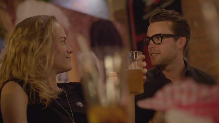 A man and woman drink and chat at a restaurant