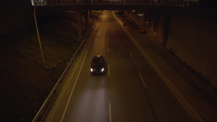A car drives on a city street at night