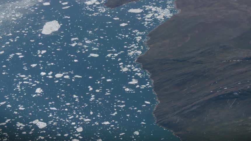 Aerial view of ice flows near a barren landscape of cliffs