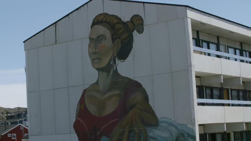 A large mural is painted on the side of a building