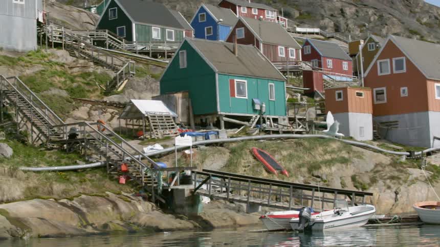 A seagull flies near a coastal village