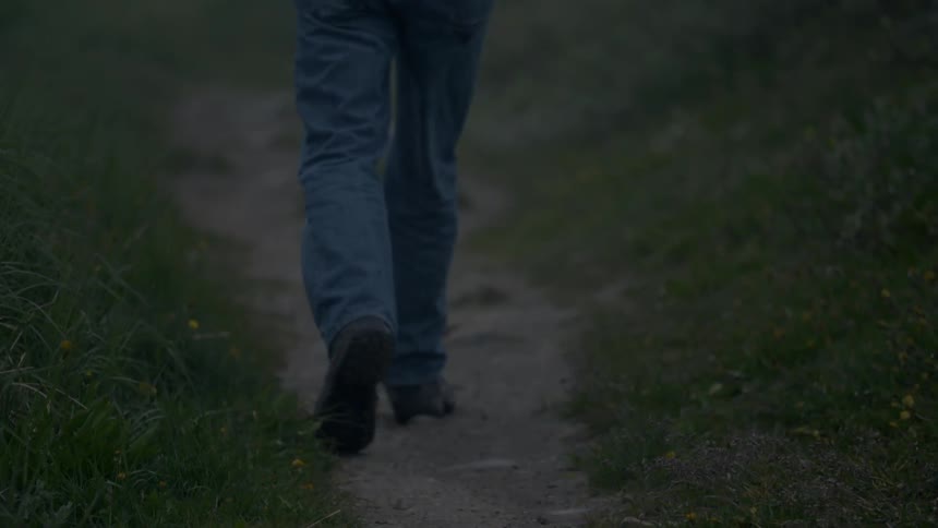 A man walks down a dirt path