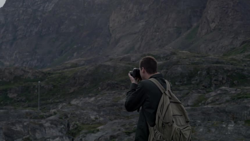 A hiker takes a photograph in the wilderness