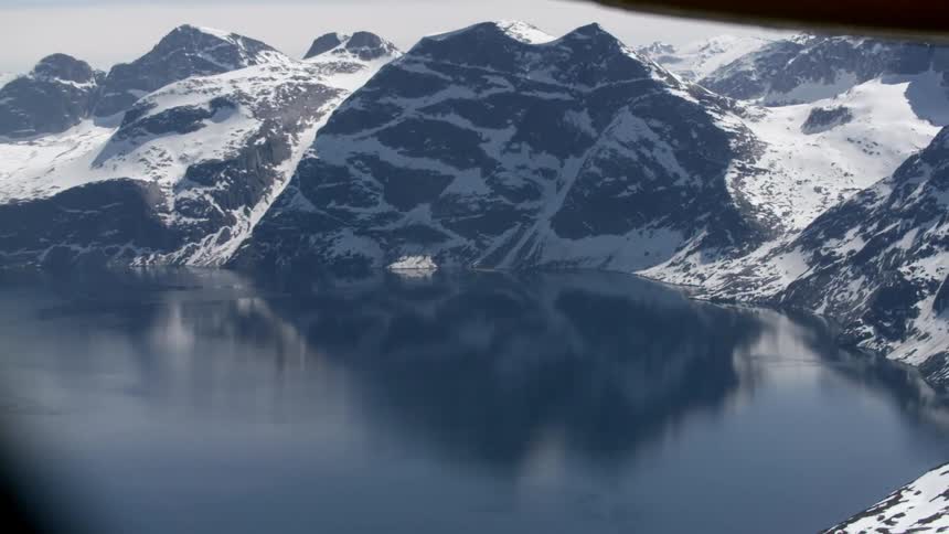 Snow-covered mountains surround a calm lake