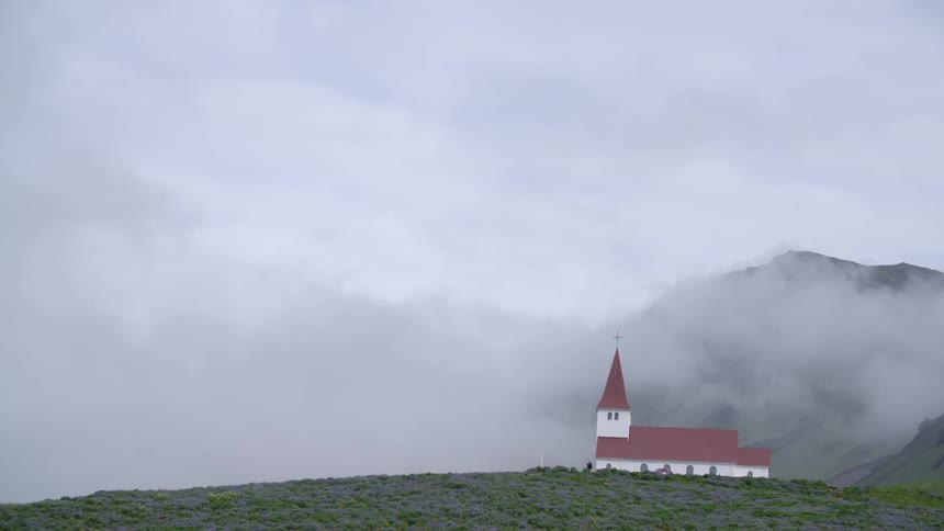 A church is seen from a far on a foggy morning