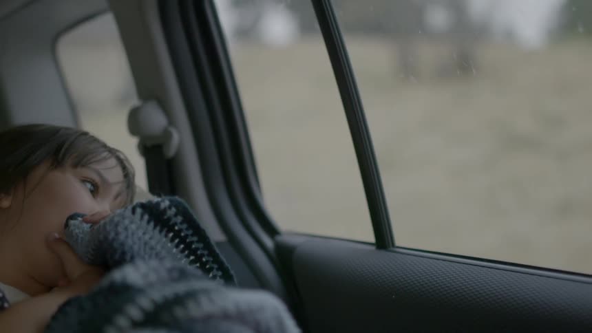 A child is riding in the backseat of the car
