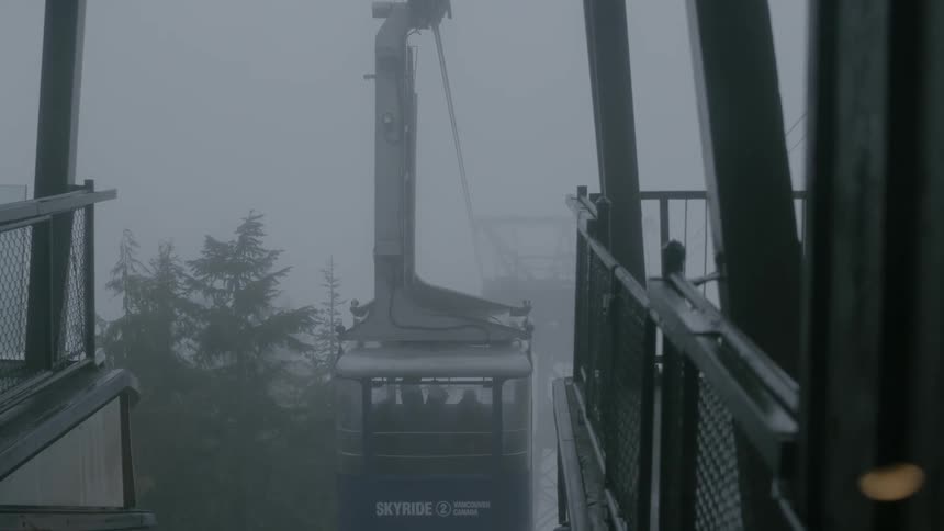 A ski lift is moving on a foggy day