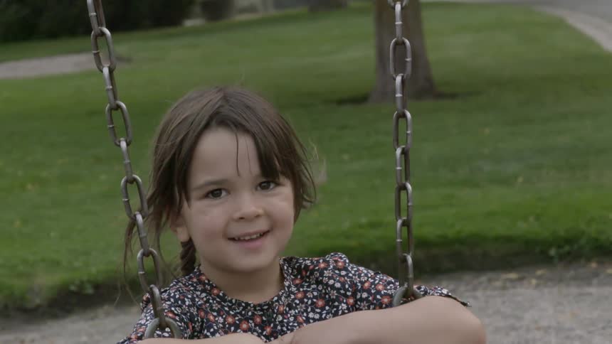 A girl swings at the park