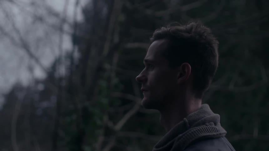 A man stands in the woods at night