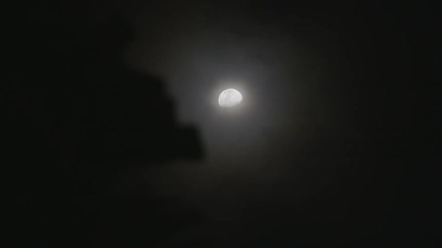 A view of the moon through fast moving, thin clouds