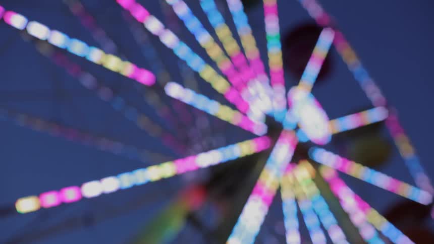 Ferris wheel turning and lit up at night