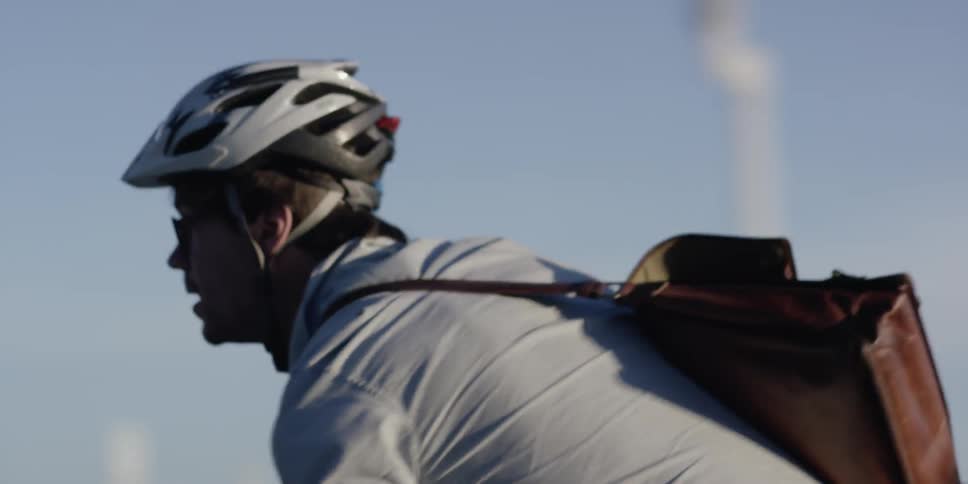Man with messenger bag riding a bicycle very fast