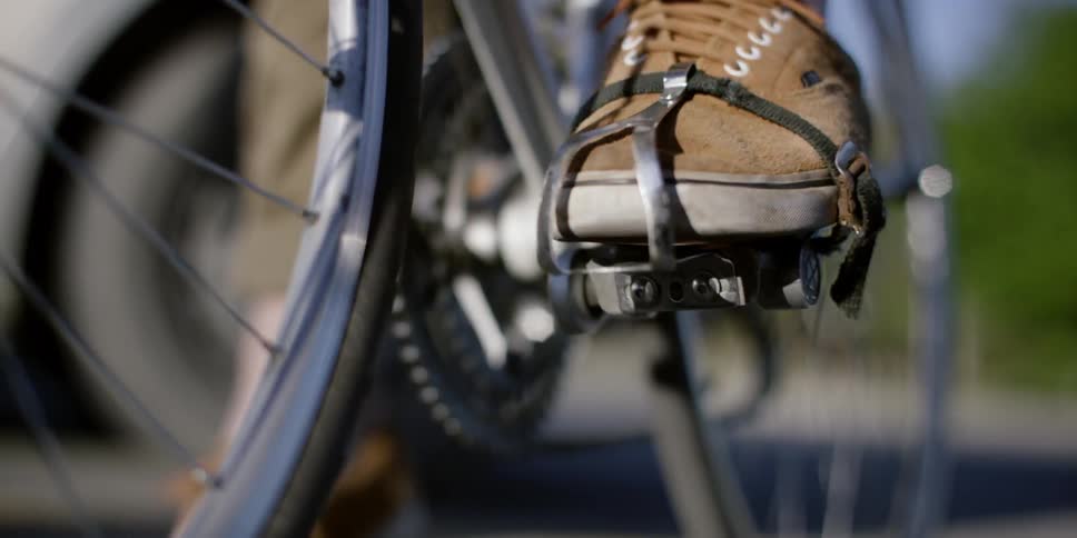A bicyclist secures his foot in the bike pedal