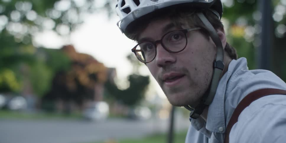 A man rides a bicycle in a residential area