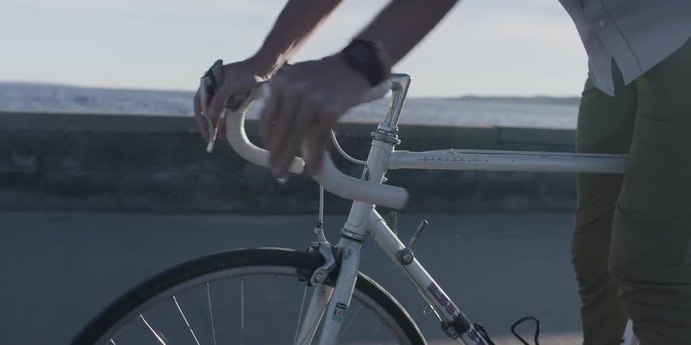 A man rides a bicycle near a beach
