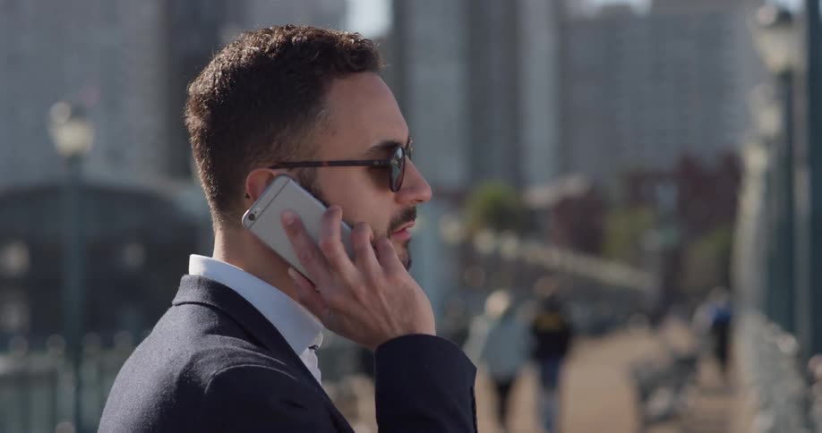 A man in a suit uses his phone outside